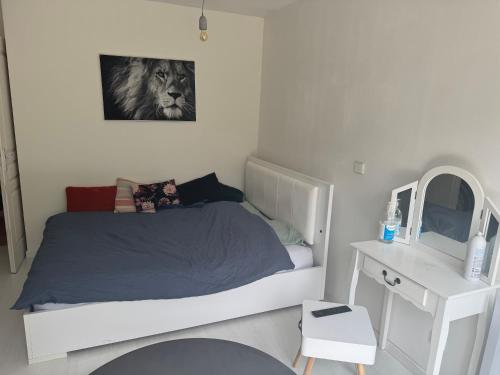 une chambre blanche avec un lit et un miroir dans l'établissement Le Clos de MANVAL, à Saint-Cyr-sur-le-Rhône