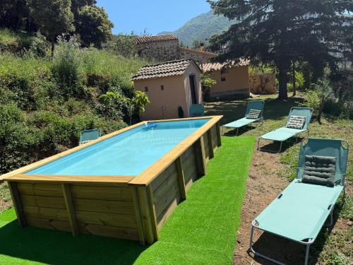 a large pool with chairs and a house at Casa Rural CAL PAGÉS Montseny in Montseny
