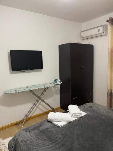 a room with a bed and a tv and a shelf at Kriss APARTMENT in Përmet
