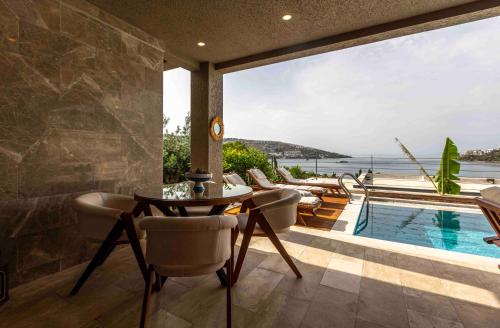 a patio with a table and chairs and a swimming pool at Marje Villas Bodrum in Bodrum City