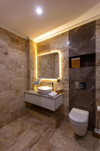 a bathroom with a sink and a toilet and a mirror at Marje Villas Bodrum in Bodrum City