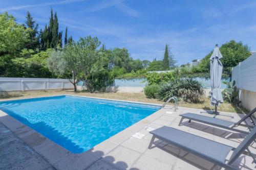 une piscine avec deux chaises et un parasol dans l'établissement La Treille Serenity, à Marseille