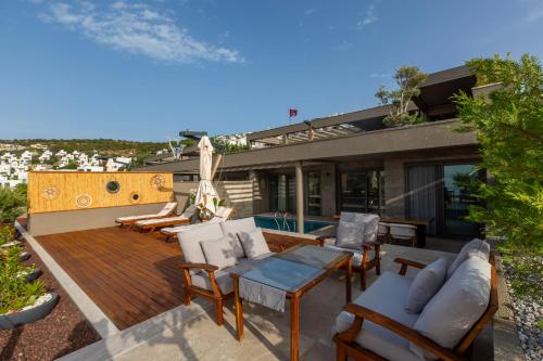 a deck with chairs and a table on a house at Marje Villas Bodrum in Bodrum City