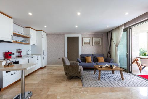 a living room with a blue couch and a table at Marje Villas Bodrum in Bodrum City