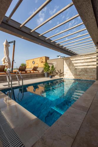 a swimming pool in a house with a roof at Marje Villas Bodrum in Bodrum City