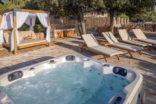 a jacuzzi tub with lounge chairs and a tent at Villa Humac Hvar in Poljica