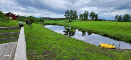 a yellow boat sitting on the side of a river at Country House surrounded by beautiful nature in Habo