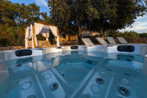 a jacuzzi tub with a table and chairs at Villa Humac Hvar in Poljica