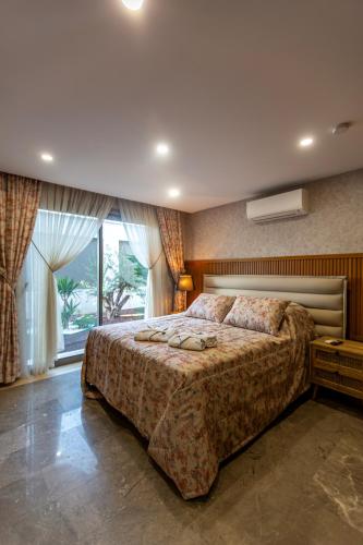a bedroom with a large bed and a window at Marje Villas Bodrum in Bodrum City