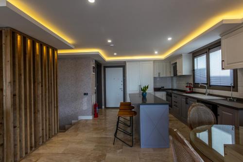 a kitchen with a counter and some chairs in it at Marje Villas Bodrum in Bodrum City