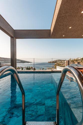 a swimming pool with a view of the ocean at Marje Villas Bodrum in Bodrum City