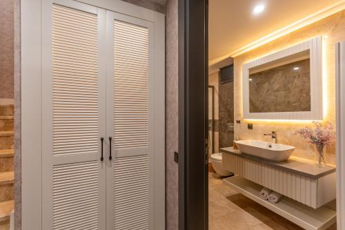 a bathroom with a sink and a toilet and a mirror at Marje Villas Bodrum in Bodrum City