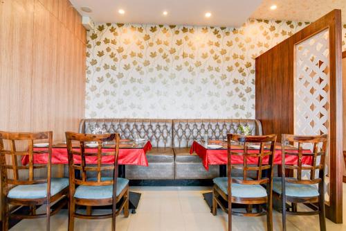 a dining room with a red table and chairs at Townhouse OAK Nilay Residency in Bhubaneshwar