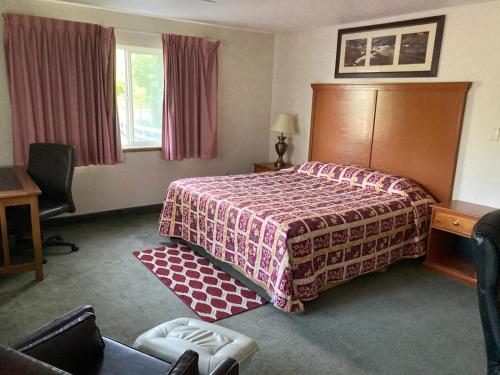 StevensonにあるCapital O Stevenson Inn Riversideのベッドと机があるホテルの部屋