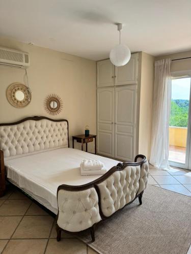 une chambre avec un grand lit blanc avec une grande fenêtre dans l'établissement La Maison Gina, à Ginasservis