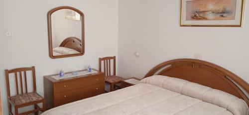 a bedroom with a bed and a dresser and a mirror at Apartamento Moraledas in Lanjarón