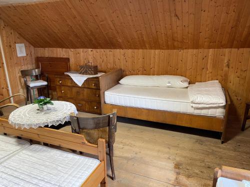 a room with two beds and a table and chairs at Urige Berghütte in Fohnsdorf