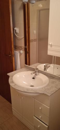 a bathroom with a white sink and a mirror at Apartamento Moraledas in Lanjarón