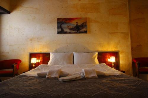 a bedroom with a large bed with two towels on it at Balloon Street Cappadocia in Avanos