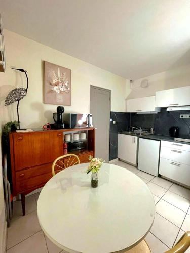 une cuisine avec une table blanche et une salle à manger dans l'établissement Le nid des Landes, à Tours