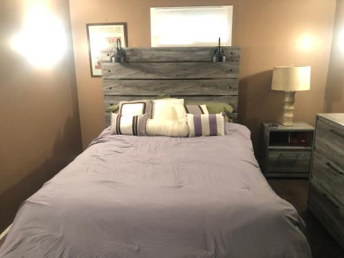 a bedroom with a white bed with a wooden headboard at Quiet Harrisburg home in Harrisburg