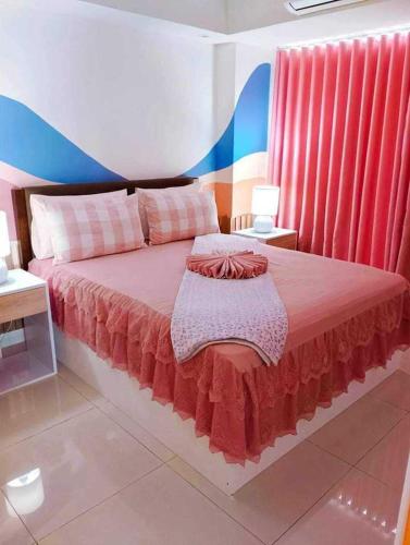 a bedroom with a large bed with red curtains at Holiday Escape Philippines in Manila