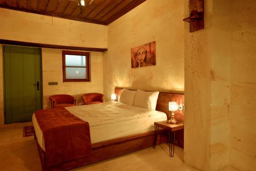 a bedroom with a bed and a table and a window at Balloon Street Cappadocia in Avanos