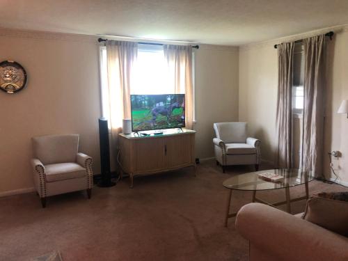 a living room with two chairs and a fish tank in a window at Quiet Harrisburg home in Harrisburg