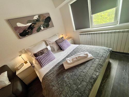 Un dormitorio pequeño con una cama grande y dos ventanas. en FLH - Liberty Home with Balcony & Free Parking, en Constanţa
