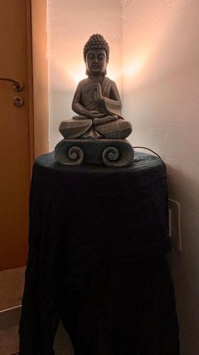 a statue of a buddha sitting on a table at Rita House Cozy Stay Near Malta Airport, Paola in Ħal Saflieni