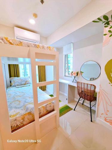 a bedroom with a bunk bed with a mirror and a desk at Holiday Escape Philippines in Manila