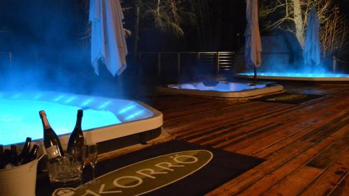 a hot tub on a wooden floor with a table with wine glasses at STF Korrö Gårdshotell - B&B in Linneryd