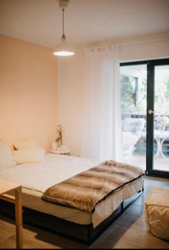 a bedroom with a large bed and a large window at Gemütliche zentrumsnahe Wohnung, eigene Terrasse in Cologne