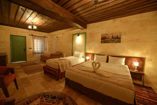 a bedroom with two beds and a couch in a room at Balloon Street Cappadocia in Avanos