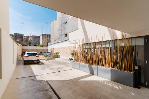 a building with a car parked in a parking lot at Glass House - Smart Rooms & Parking in Lecce