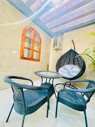 a patio with two chairs and a table and a swing at Shiv Sadan in Jaipur