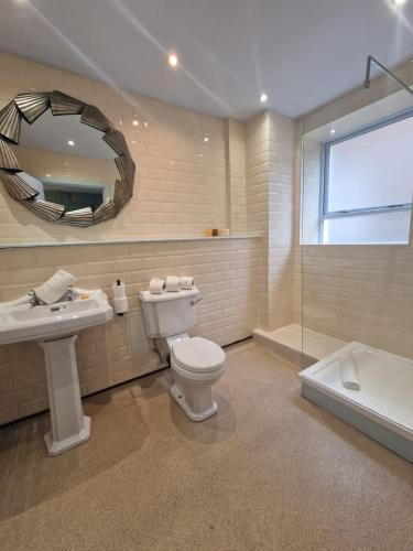 a bathroom with a toilet and a sink and a mirror at RainHill Hall Hotel in Rainhull