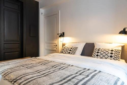 a bedroom with a large white bed with pillows at Characteristic house near the beach for 10 in Ostend
