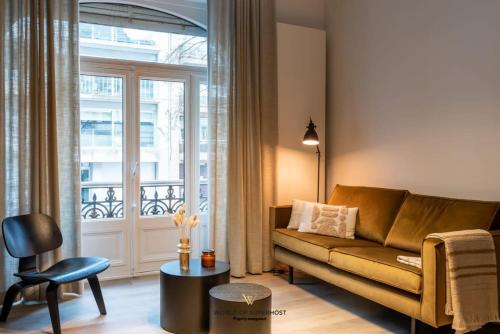 a living room with a couch and a large window at Characteristic house near the beach for 10 in Ostend