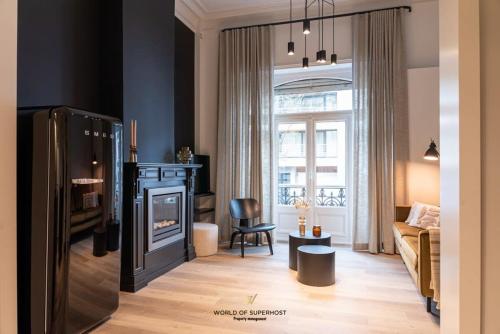 a living room with a fireplace and a couch and a chair at Characteristic house near the beach for 10 in Ostend