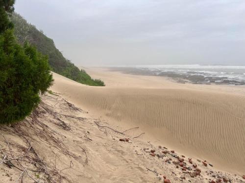 a view of a sandy beach next to the ocean at Kalashe Bed & Breakfast in East London