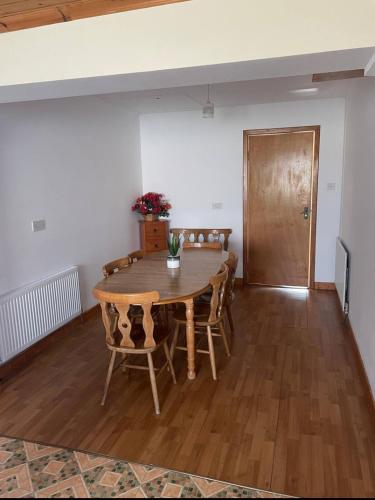 a dining room with a wooden table and chairs at The Bungalow in Ballinrobe