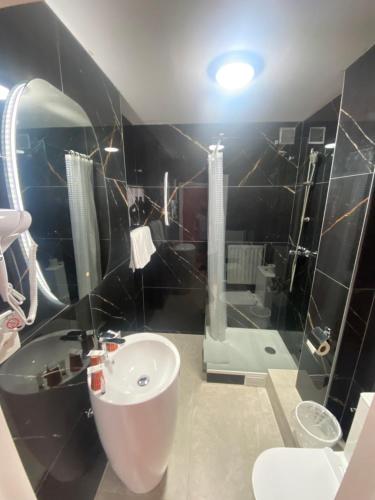 a bathroom with a sink and a toilet and a mirror at Hotel Windsor in Brussels