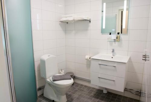 a white bathroom with a toilet and a sink at GEG Hotel in Landskrona