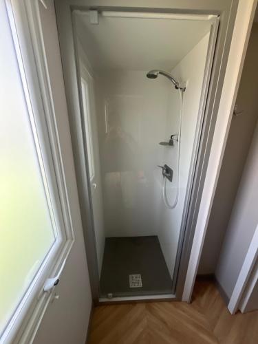 une douche avec une porte vitrée dans une salle de bain dans l'établissement Mobil-Home neuf Valras-Plage - Camping 4 étoiles les Sables du Midi, à Valras-Plage