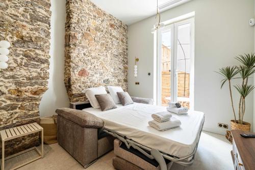 une chambre avec un lit et un mur en pierre dans l'établissement Magnificent apartment - AC-1BR-4P- Cannes, à Cannes