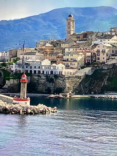 une vue d'une ville depuis l'eau avec un phare dans l'établissement Centre historique bastia, à Bastia