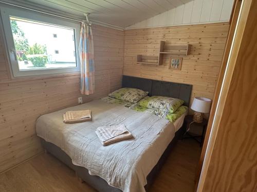 a bedroom with a bed with two towels on it at KAMERALNY przy promenadzie - domki, apartamenty, pokoje in Charzykowy