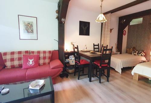 a living room with a red couch and a table at Begonie2 in Siegsdorf