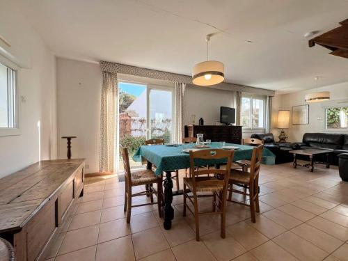 une cuisine et un salon avec une table et des chaises dans l'établissement Maison cosy à Carnac - 3 chambres, terrasse, jardin, wifi - 150m de la plage - FR-1-377-34, à Carnac
